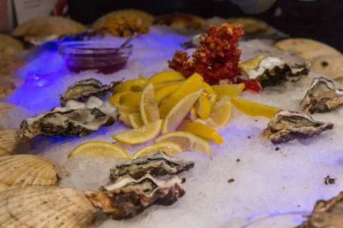 Serving place with ice, lemons, shells and oyster sauce 스톡 사진