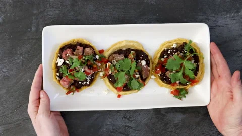 Serving a Plate of Black Bean Sopes Stock Footage 194591733