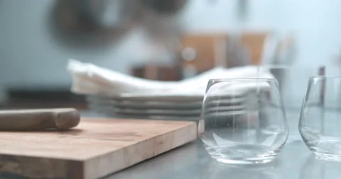 Serving plate chopping block knives and glasses being displayed in ultra slow mo Stock Footage 199456678