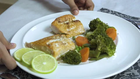 Serving a plate of roasted salmon slices with boiled vegetables Stock Footage 134840821