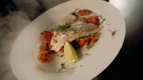 Serving prepared fish on the plate in motion Stock Footage 125458542