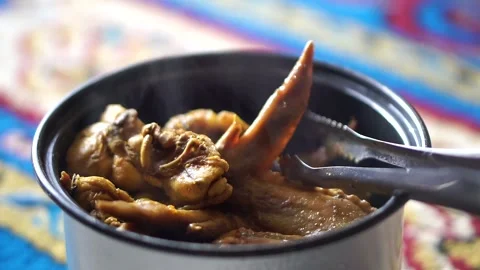 Serving process of boiled chicken wings using tongs, illustrating a simple 動画素材 325613779