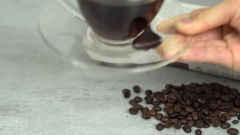 Serving put down coffee glass cup with coffee beans and newspaper Stock Footage 113003623