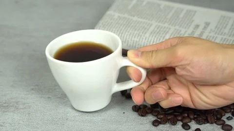 Serving put down coffee white cup with coffee beans and newspaper Stock Footage 113003607