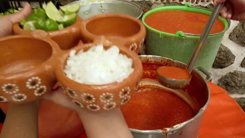 Serving Red Salsa into Traditional Clay Bowls with Chopped Onion and Lime in Stock Footage 340192914