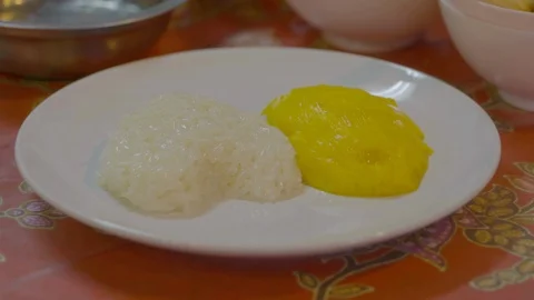 A serving of rice and mango on a white round plate Stock Footage 116607221
