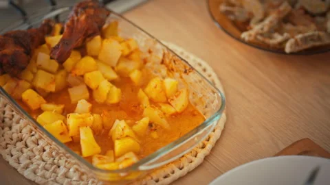 Serving roast meat and baked potatoes. A housewife arranges food on a plate Stock Footage 344876934