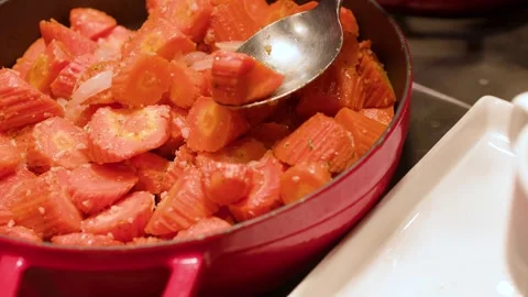 Serving Roasted Carrots from a Red Pot at a Luxury Buffet Stock Footage 334833368