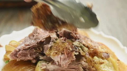 Serving roasted lamb shoulder with vegetables. Stock Footage 195531237