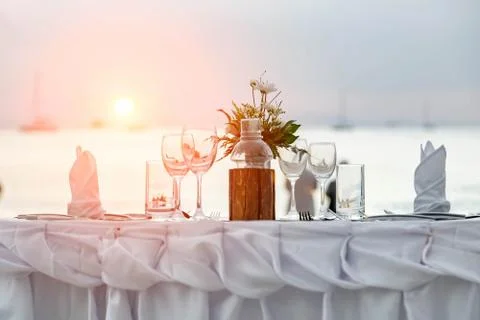 Serving for a romantic dinner on the beach at sunset. Stock Photos