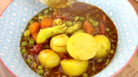 Serving A Rustic Vegetable Stew Into A Bowl Using A metal Ladle. 스톡 동영상 134345313