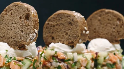 Serving a salad with lime and bread in a white plate on a black background in 4k Stock Footage 99223576