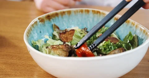 Serving salad with tomatoes, fresh cooked mix of vegetables and meat pieces. Stock Footage 133392617