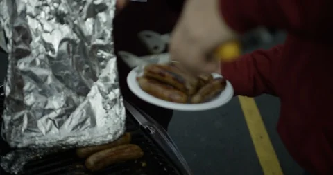 Serving sausages or brats bratwurst off portable grill 2 Stock Footage 123785206