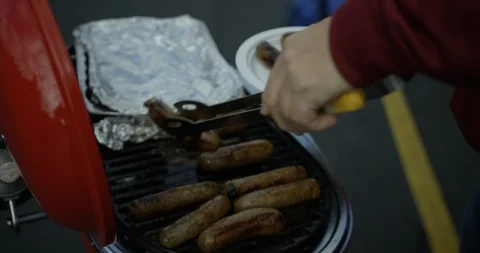 Serving sausages or brats bratwurst off portable grill 1 Stock Footage 123785389