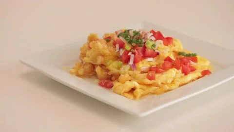 Serving scrambled eggs in a white plate Stock Footage 133815107