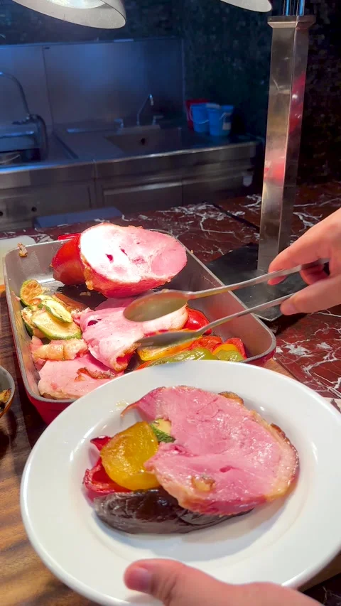 Serving Sliced Roasted Ham and Grilled Vegetables at a Hotel Buffet Stock Footage 336352212
