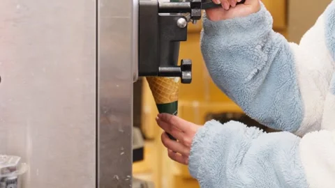 Serving Soft-Serve Ice Cream from Machine into Cone at Dessert Counter Stock Footage 312484821