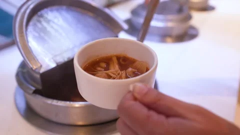Serving Spicy Thai Tom Yum Soup with Ladle at Buffet Stock Footage 336704915