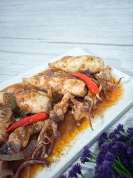 A serving of squid sambal on a white plate. Stock Photos