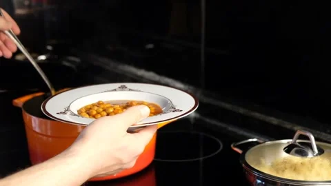 Serving Steaming Hot Chickpea Stew from a Cast Iron Pot into a Plate Stock Footage 274893569