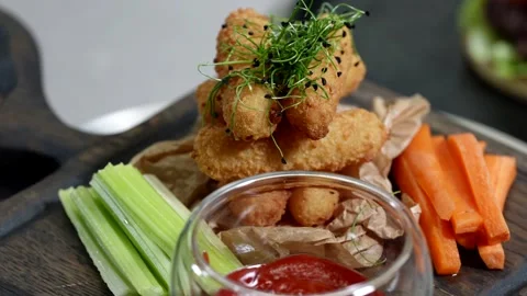 Serving sticks with carrots, celery and ketchup on a wooden board  Stock Footage 313868953