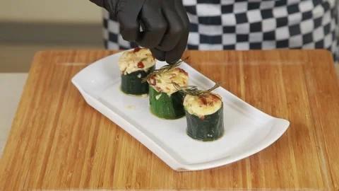 Serving stuffed and baked zucchini barrels on a plate Video stock 318282996