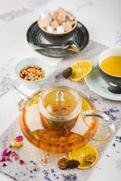Serving table for breakfast, orange tea in teapot and cup on a white table Stock Photos