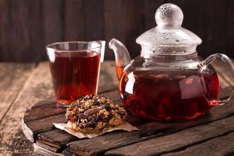 Serving table for breakfast, red tea in teapot and granola on a wooden table Stock Photos