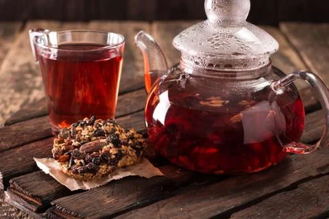 Serving table for breakfast, red tea in teapot and granola on a wooden table Stock Photos