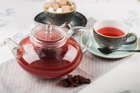 Serving table for breakfast, red tea in teapot and cup on a white table Stock Photos