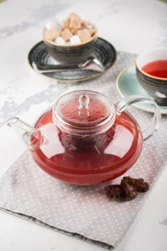 Serving table for breakfast, red tea in teapot and cup on a white table Stock Photos
