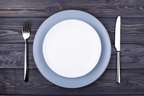 Serving table with empty plate. Stock Photos