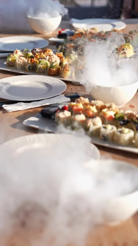 Serving the table with food and drinks with vessels with dry ice. Smoke on the Stock Footage 311796470