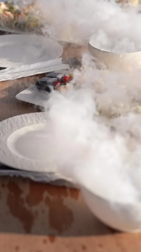 Serving the table with food and drinks with vessels with dry ice. Smoke on the Stock Footage 334854778