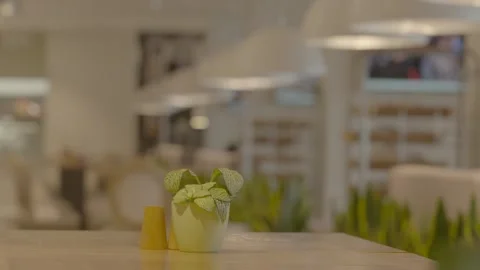 Serving table, indoor plants, pot with plant, green, TV, orange clothes Stock Footage 303407011
