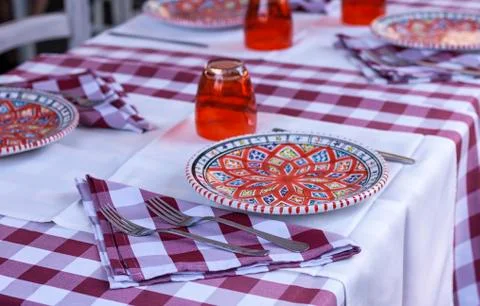 Serving on the table in the restaurant: plates, glasses and napkins Stock Photos