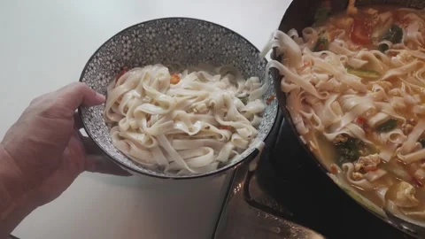 Serving Tomato Egg Noodles from an Iron Wok into a Large Bowl Stock Footage 346308328
