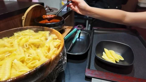 Serving Tomato Sauce Over Penne Pasta at a Buffet Stock Footage 340862703