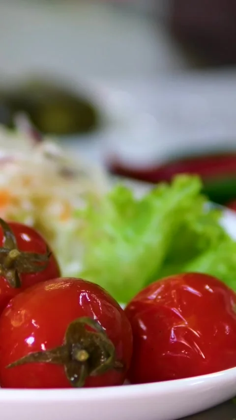 Serving of traditional fermented vegetables pickled tomatoes cucumbers and Stock Footage 320724223