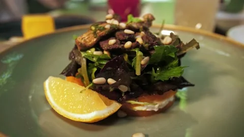 Serving Veal Salad in a restaurant. Young couple dining at a restaurant. Lig Stock Footage 202478093
