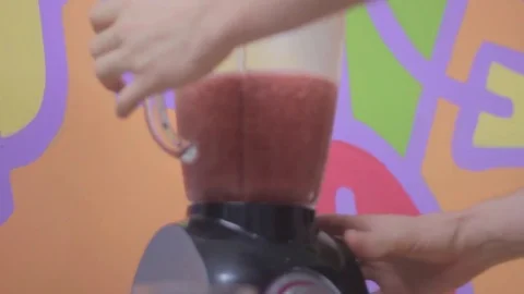 Serving watermelon juice on a cup and taking it with the left hand Stock Footage 79538341