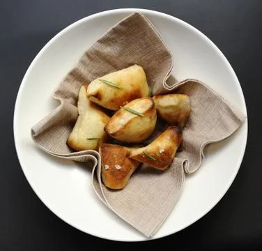 Servings of bread served in nice white plate on black table Stock Photos