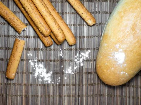 Sesame biscuits and bread on the table. Biscuits are elongated in the form of Stock Photos