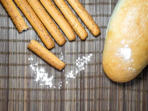 Sesame biscuits and bread on the table. Biscuits are elongated in the form of Stock Photos