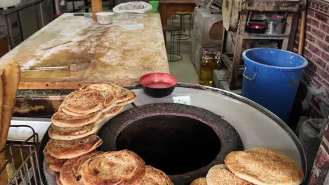 Sesame Pastries and Flatbreads Displayed Beside Round Griddle Stock Footage 340176830