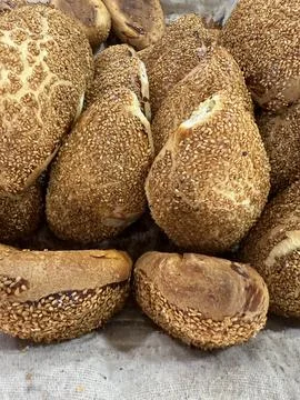 Sesame seed-covered bread rolls in a basket, showing a rustic texture and n.. Foto stock