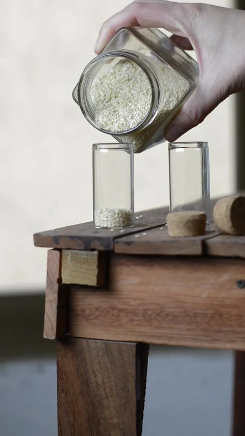 Sesame seed inside a small jar on a wooden table Stock Footage 241903166