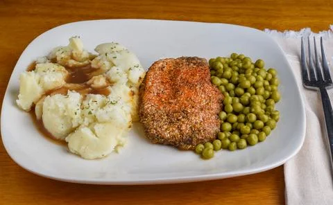Seson pork chop served with mash potatoes and peas Stock Photos
