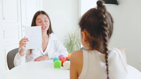 Session between speech therapist and child focused on letter recognition with Stock Footage 315539696
